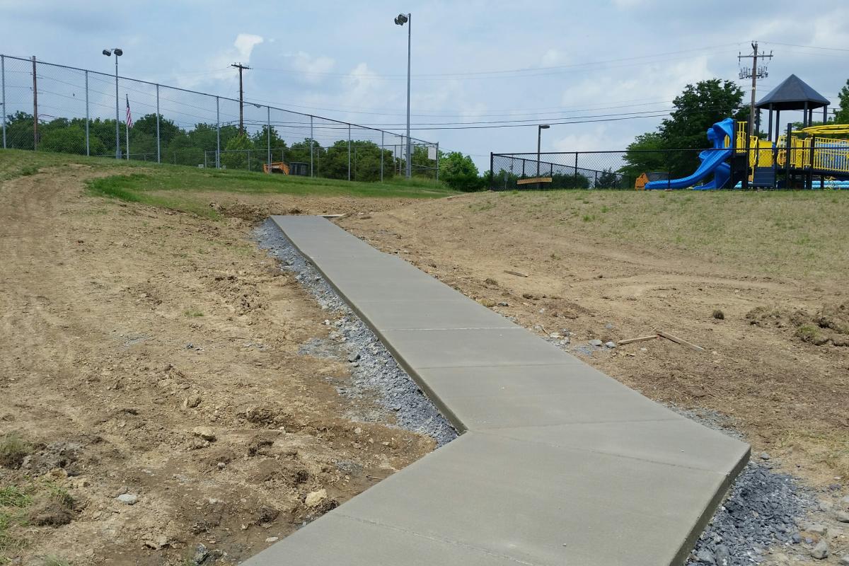 New sidewalk leading from playground to softball field.